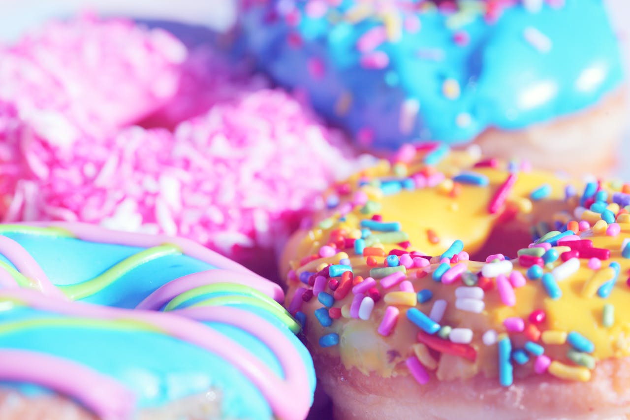 Offerings Close-up of assorted donuts with colorful icing and sprinkles, showcasing sweet indulgence.