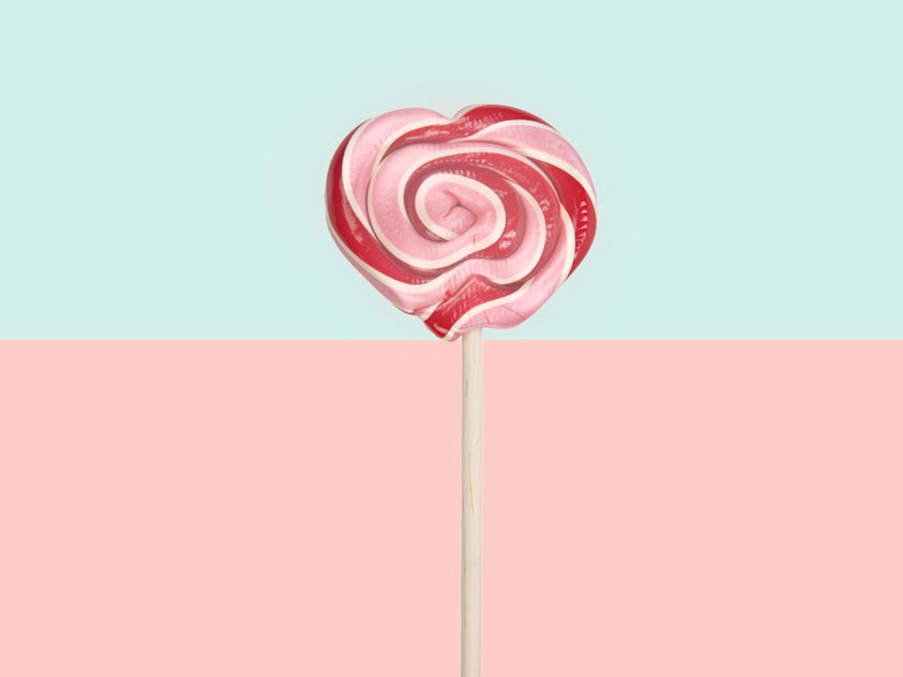 Offerings A vibrant pink heart lollipop on a pastel split background, perfect for sweet themes.